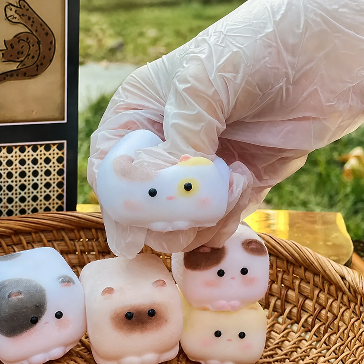 Cube Cat silicone squishies held above a wicker basket